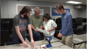 Students study technical plans to build a plane.